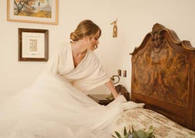 La sposa poggia l'abito sul letto